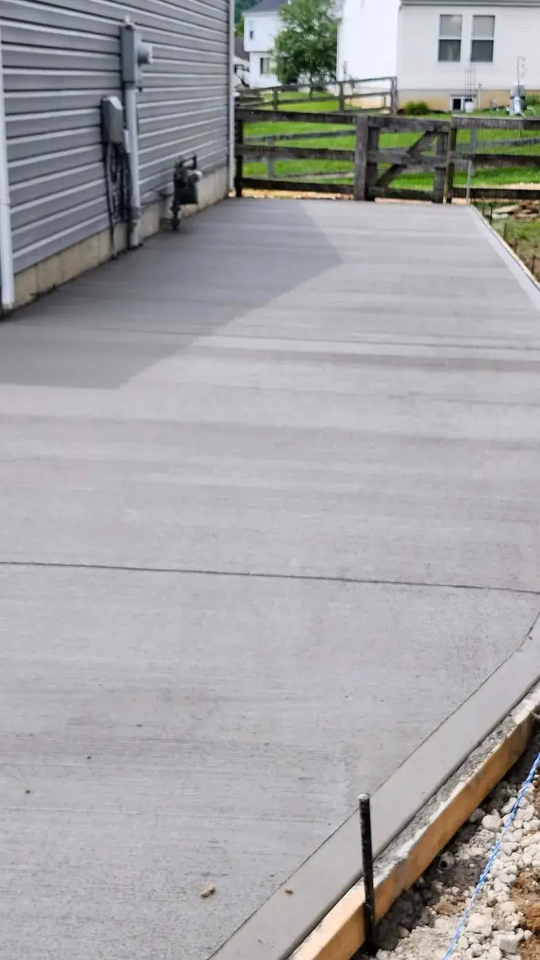 Wide concrete drive pad poured beside a commercial building