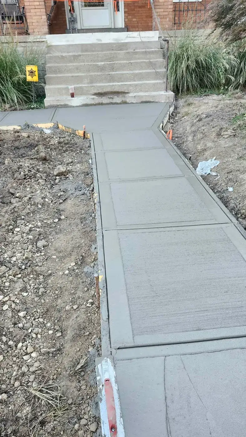 New concrete sidewalk poured up to a set of steps